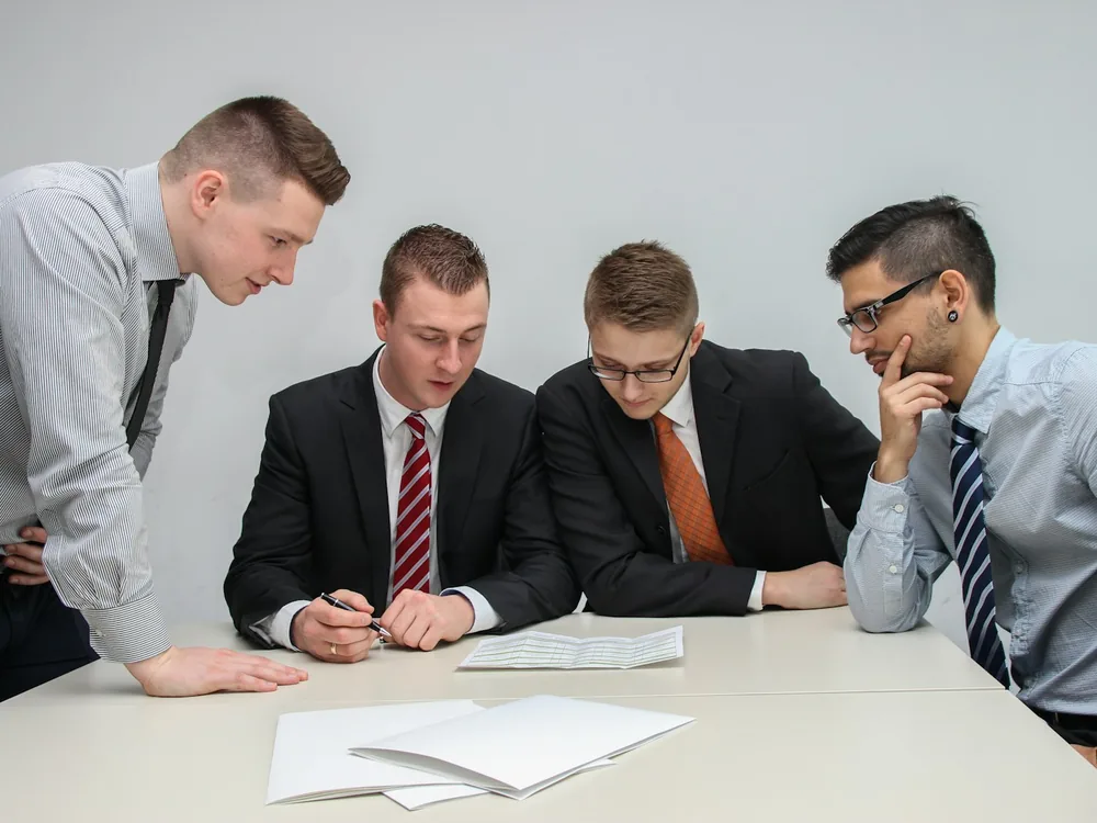 Sales team in coordinated branded shirts reviewing documents
