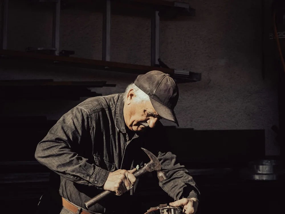 Tradesperson in durable branded work wear at a workbench